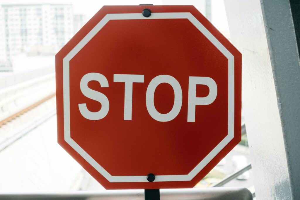 Close-up of a red stop sign with urban background, emphasizing safety and caution.