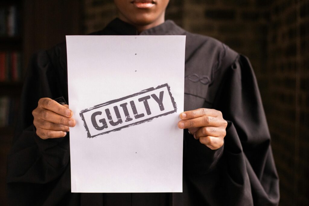 A judge in a courtroom holding a paper with a guilty verdict, symbolizing law and justice.